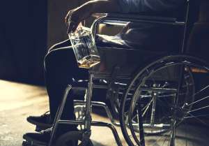 Alcoholic man sitting in a wheelchair