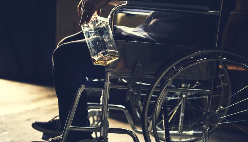 Alcoholic man sitting in a wheelchair