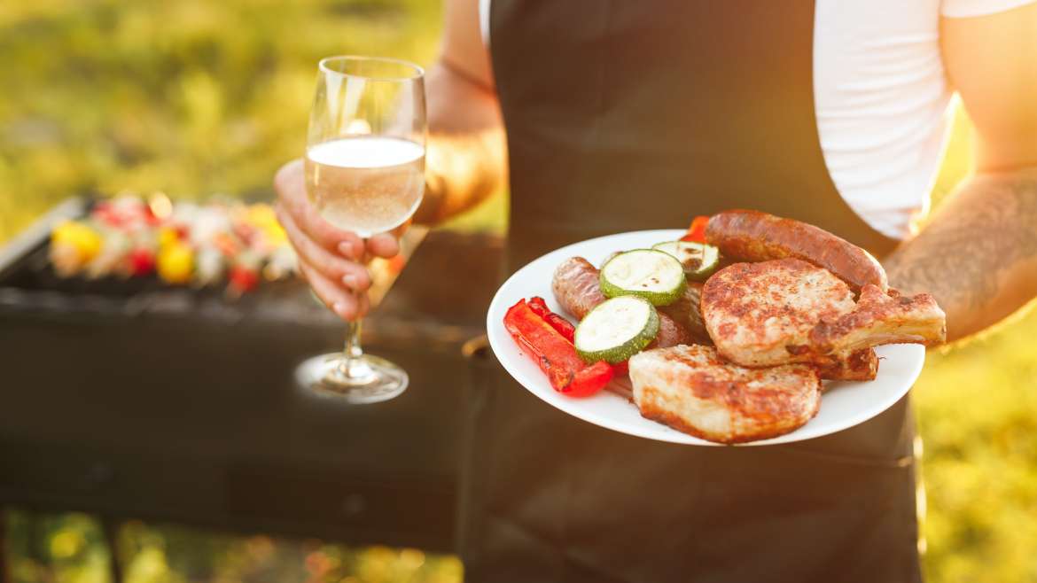 Faceless male with grilled food and wine