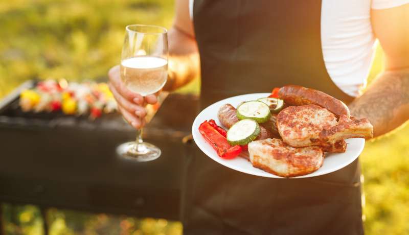 Faceless male with grilled food and wine